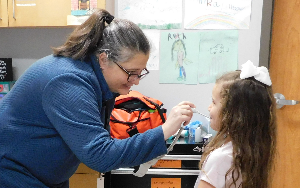  School nurse checking the temperature of a female student